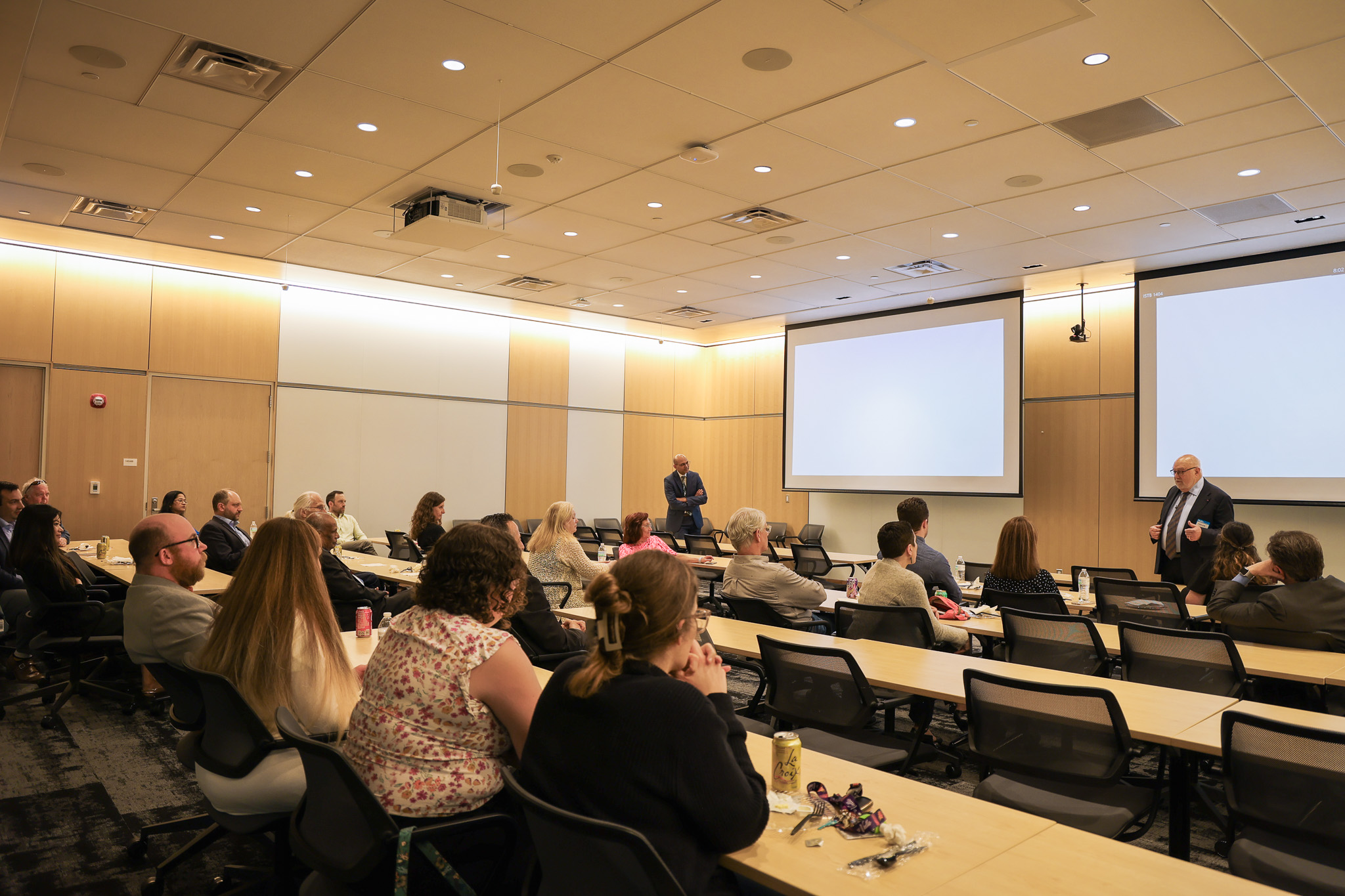 a lecture hall filled with people listening to the speaker