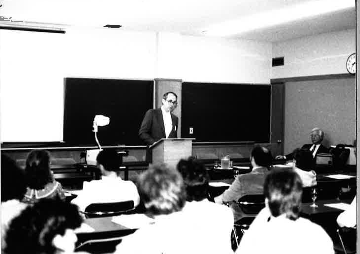 A black and white photo of Dr. Dean lecturing in a classroom